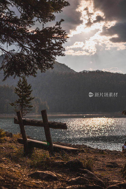 阳光下的木凳，可以看到美丽的山景和湖景