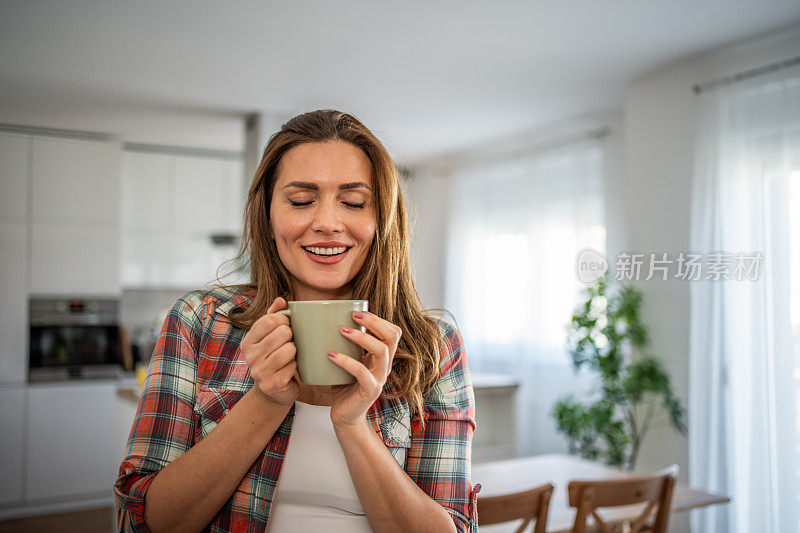 早晨舒缓的节奏——一位年轻女子在厨房里享受着早晨的咖啡