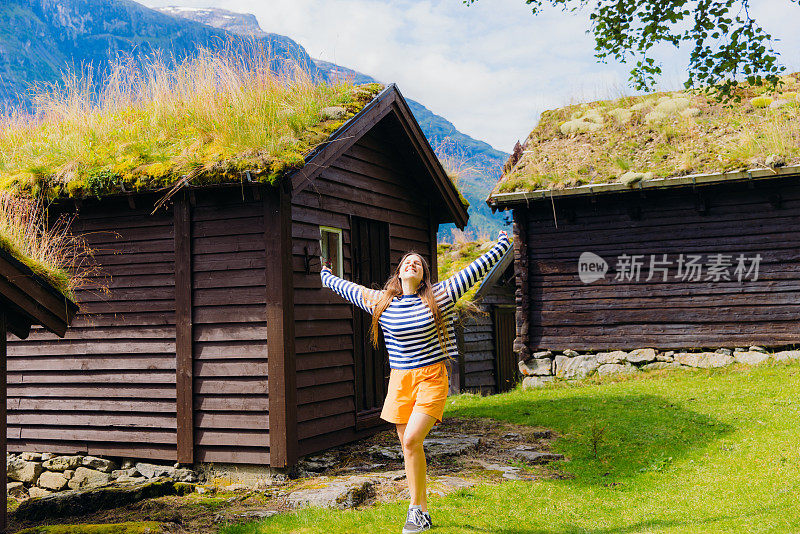 快乐的女游客在挪威的老维京村沉思阳光明媚的夏天