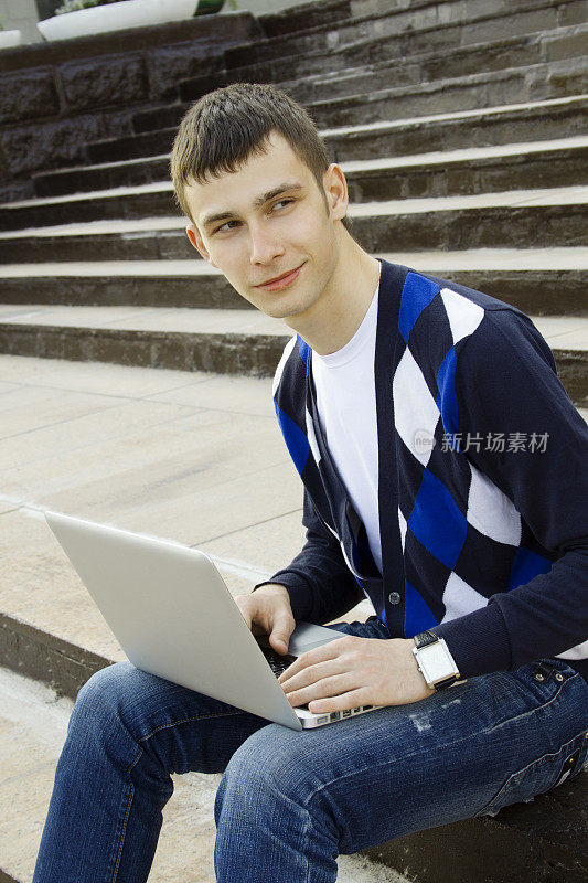 年轻的学生在用笔记本电脑工作