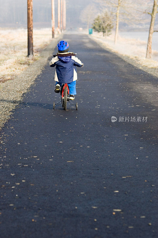 小男孩骑在小路上