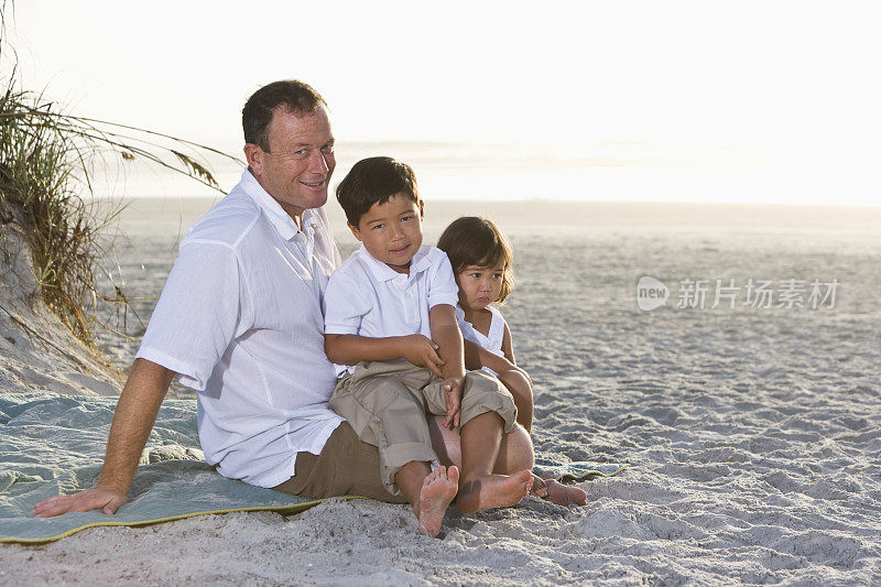 多民族家庭，父亲和孩子们在海滩上