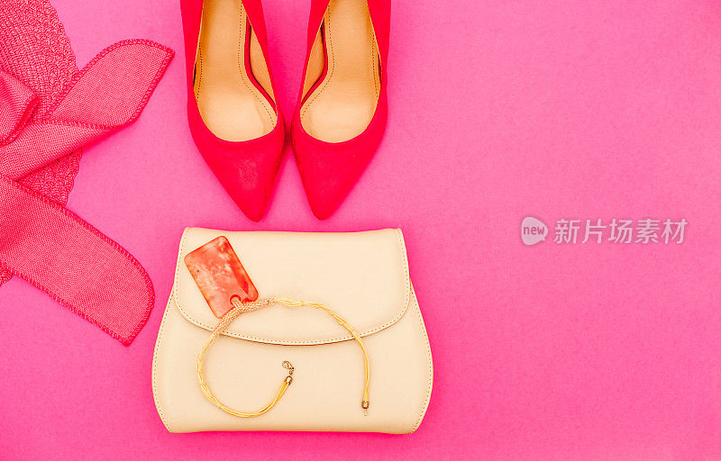 白色手提包和粉红色优雅的鞋在粉红色的背景