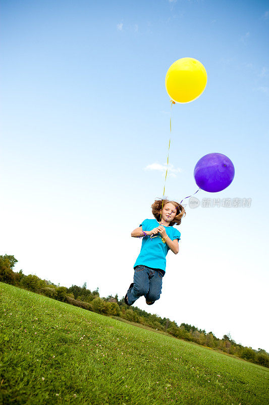 快乐的小女孩和气球在外面跳