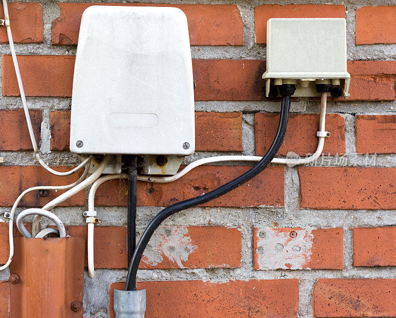 室外电话连接线连接在红砖墙上。