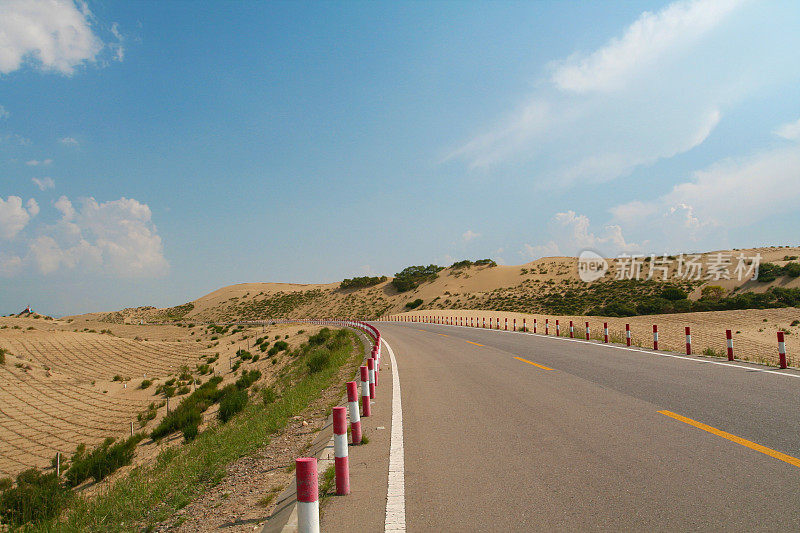 蜿蜒的道路穿过青海湖旁的沙丘