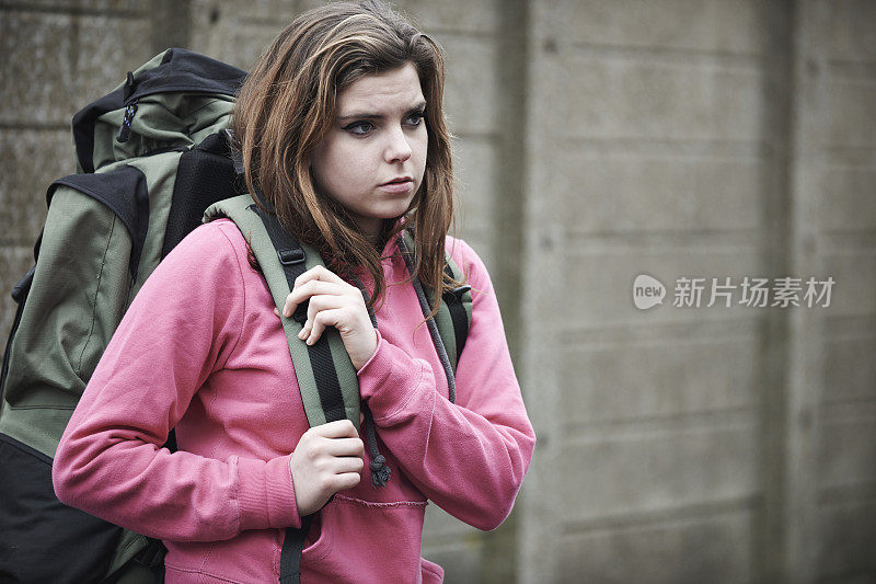 无家可归的少女在街上背着背包