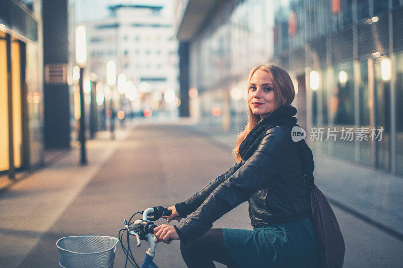 年轻女子骑自行车在城市