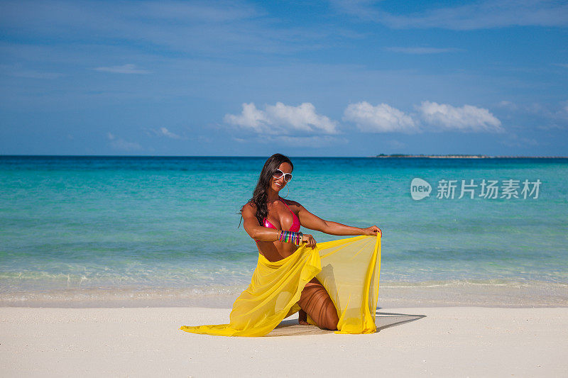 海滩上戴着黄色面纱的女人