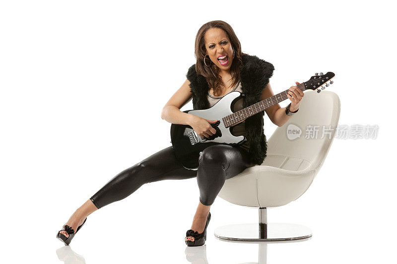 坐在椅子上弹吉他的女性