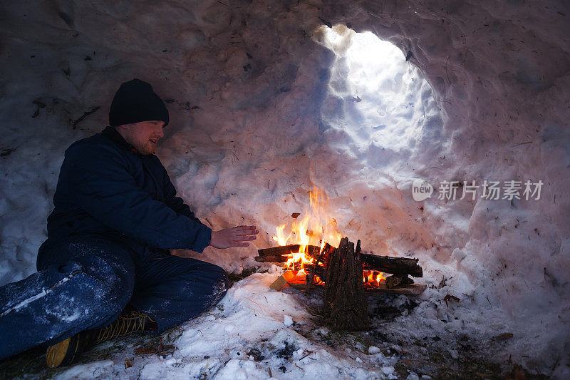 一名男子在冰屋中用火取暖
