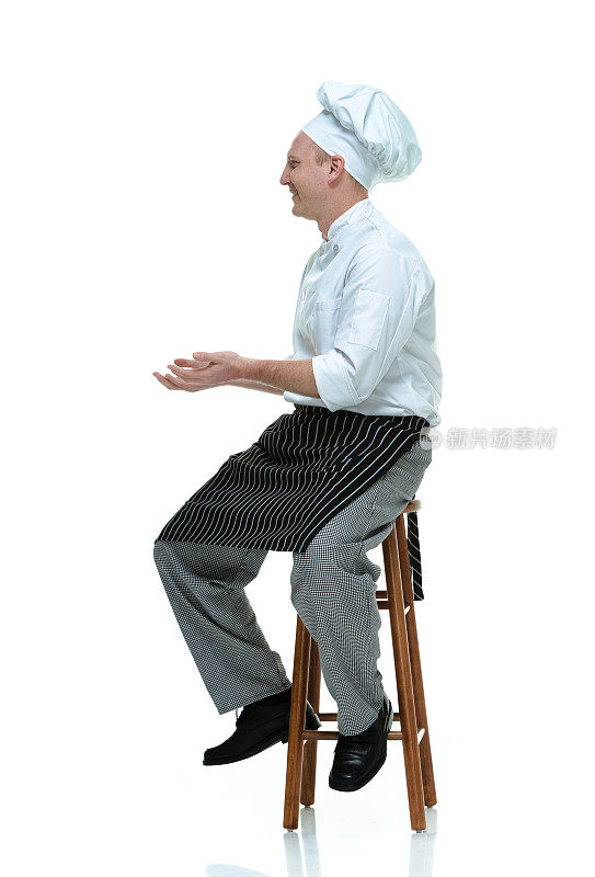 快乐的厨师坐在凳子上呈上