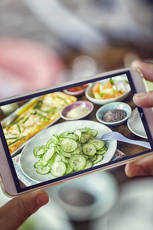 用智能手机拍芝麻黄瓜沙拉