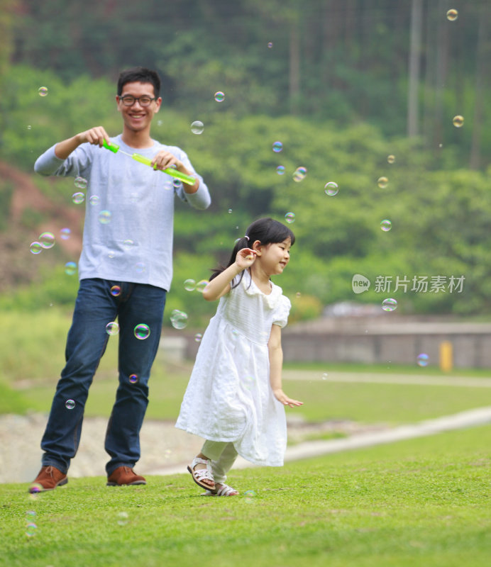 快乐的小女孩和家人在花园里玩