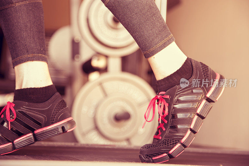 体育运动:女运动员在健身房跑步机上跑步。锻炼。