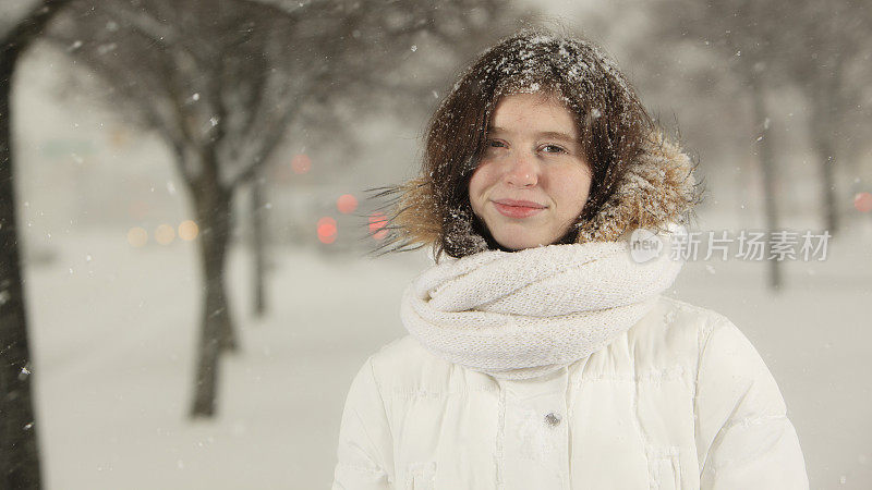 雪下穿着白色夹克的漂亮少女