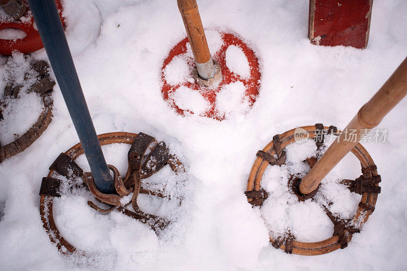 旧的滑雪棍插在雪地里