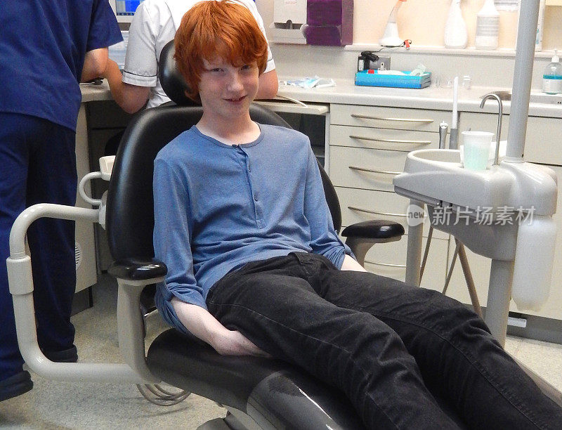 一个焦虑的男孩坐在牙医椅上，牙痛，牙齿，牙医预约