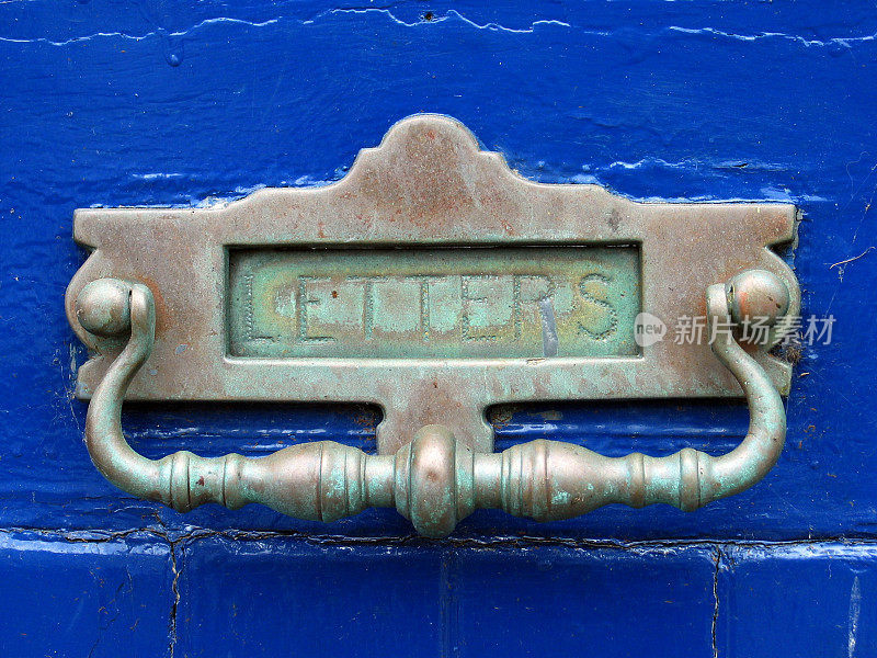 旧的黄铜信箱和蓝色门上的门环