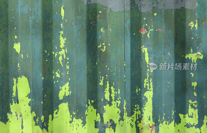 锈迹斑斑的金属上有剥落的油漆，底色为绿、黄、蓝