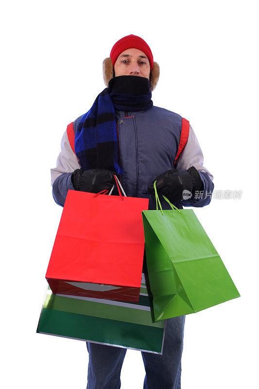 冬大衣男人与针织帽:购物者持有礼品袋