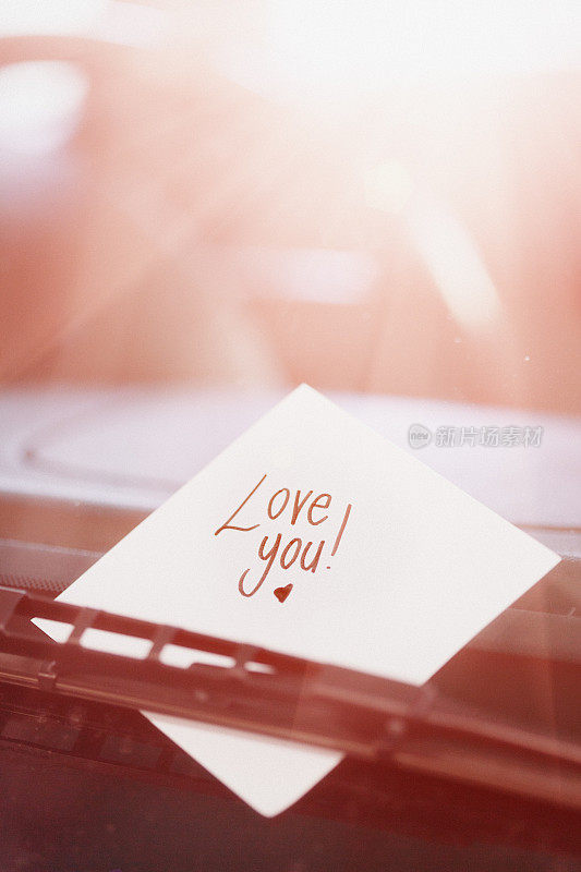 挡风玻璃刮水器下的手写纸条上写着“爱你”