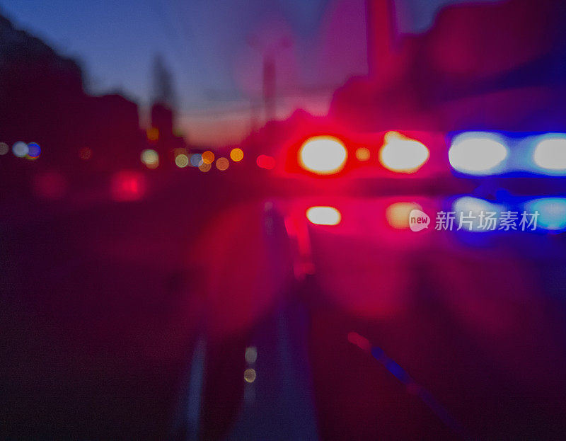 红、蓝:夜间警车的灯。夜间巡逻城市。抽象模糊的图像。