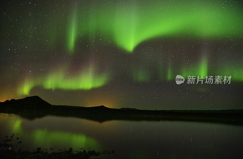 美丽的北极光掠过冰岛的湖面。