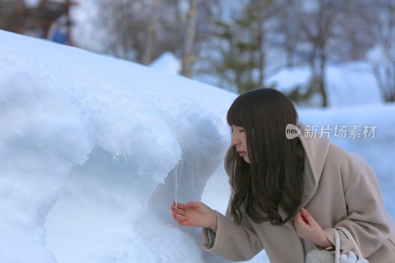 一个年轻女子从堆积的雪中出现