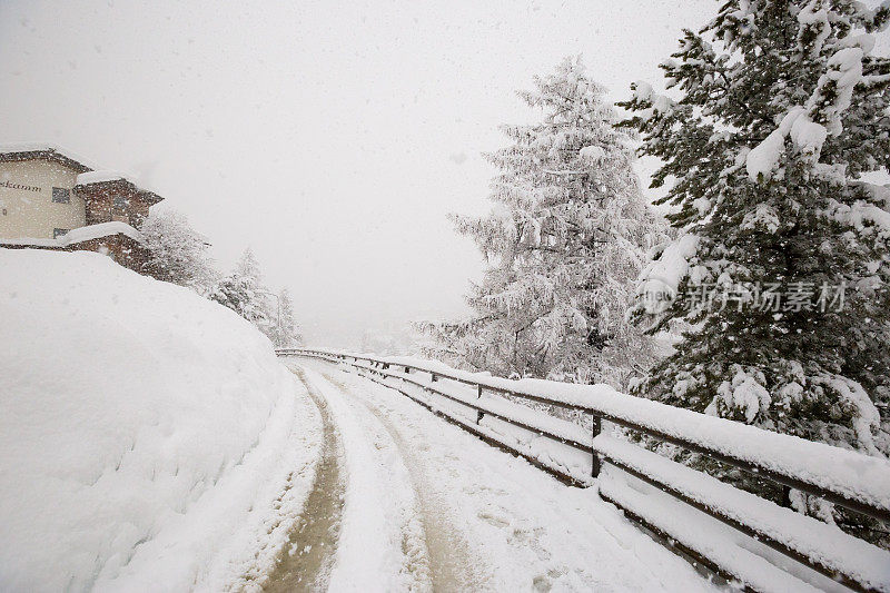 一场暴风雪中，一条被雪覆盖的道路蜿蜒穿过瑞士策马特滑雪场