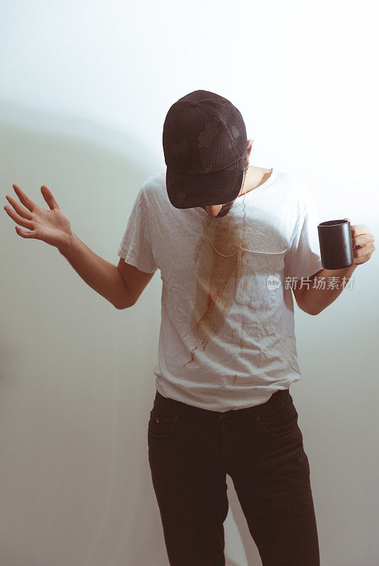 年轻人把咖啡洒在t恤上