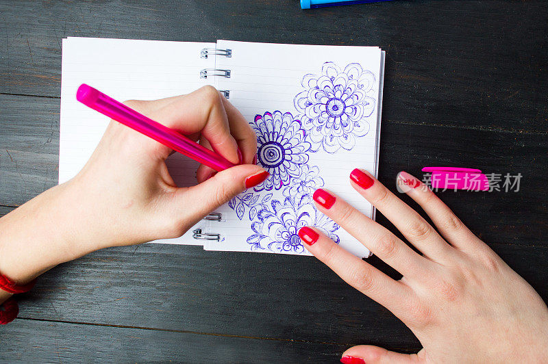 女性在笔记本上画花的形状