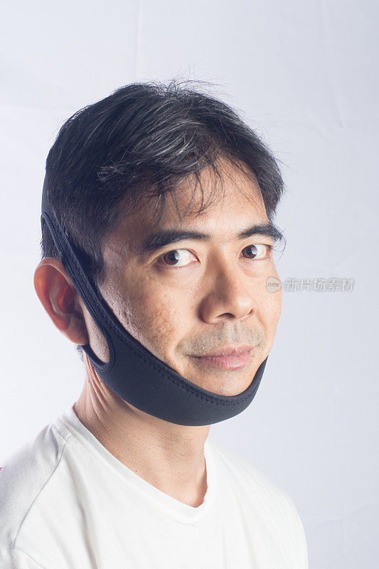 成年亚洲男子戴着下巴带和微笑