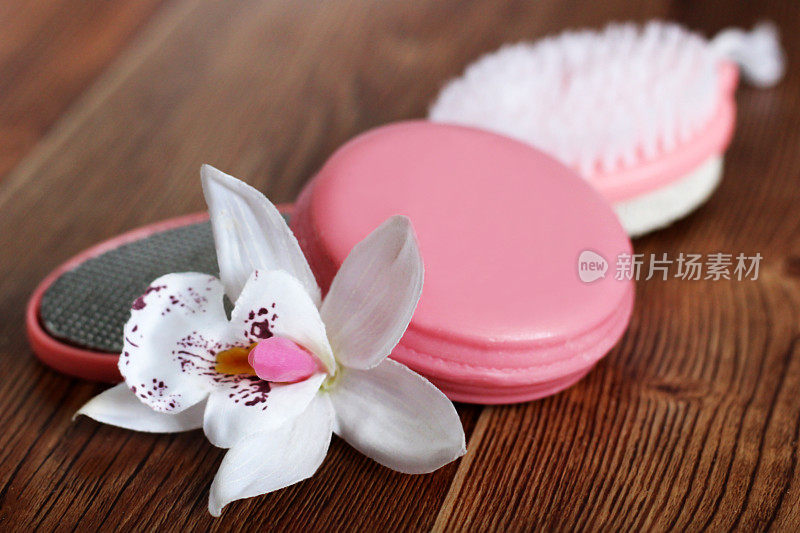 粉色浮石女性脚，肥皂和兰花在木制背景