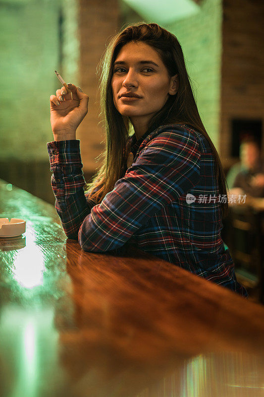在酒吧里抽烟的漂亮女人。