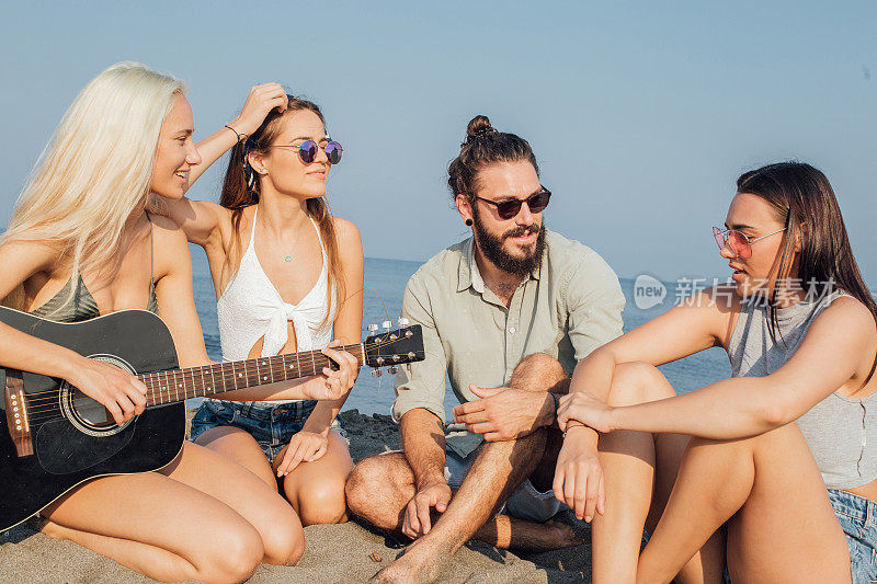 一群年轻人在海滩上弹吉他