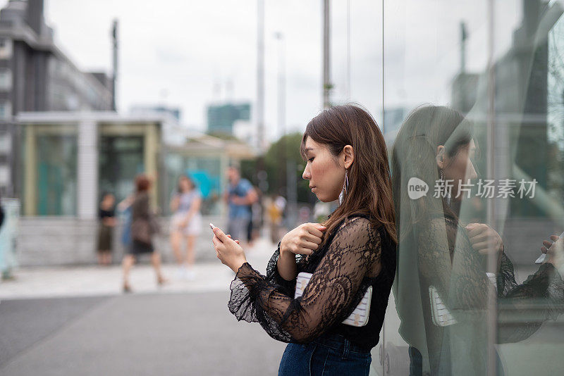 一名女子走在原宿车站附近的街道上，原宿是日本著名的观光胜地