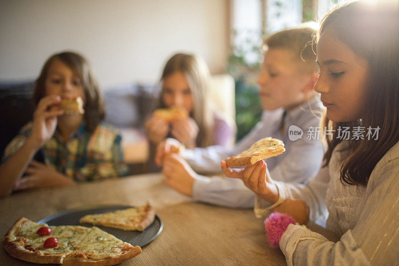 孩子们吃披萨时玩得很开心