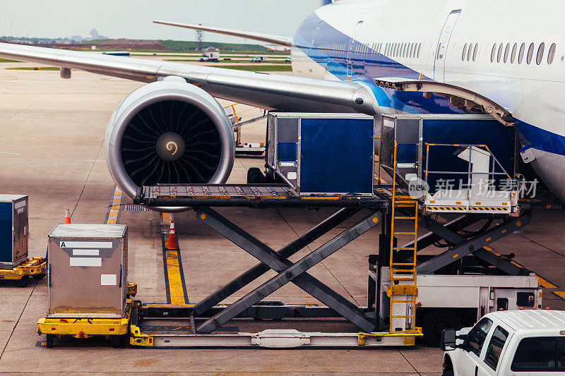 飞机机翼和发动机与货物在停机坪上的视图