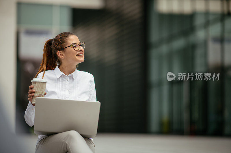 年轻漂亮的女商人一边打电话一边喝咖啡