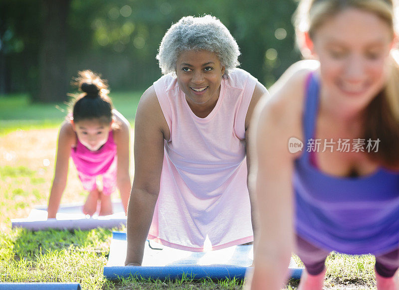 快乐的非裔美国老年妇女在户外做瑜伽或健身课