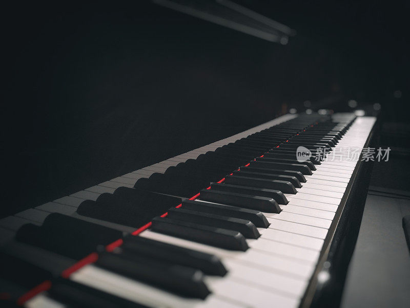 大钢琴键盘的特写，漂亮的乐器，在移动设备上拍摄的暗光