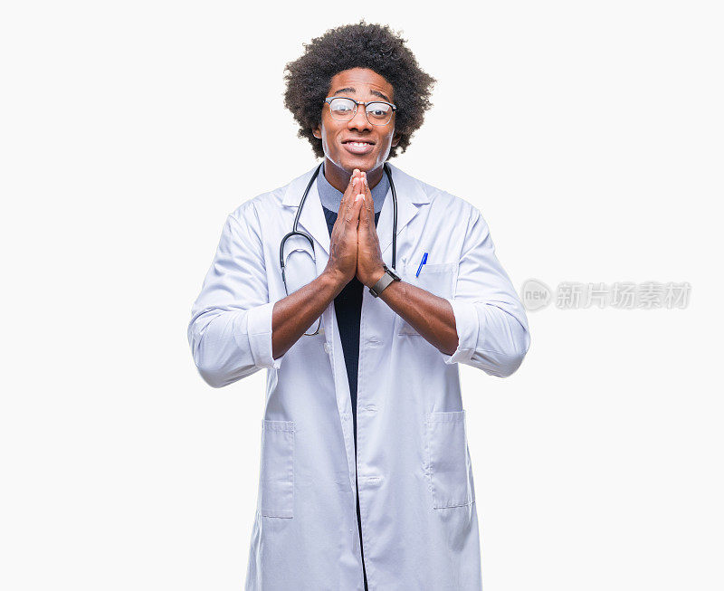 非裔美国医生在孤立的背景祈祷与手一起请求宽恕自信的微笑。