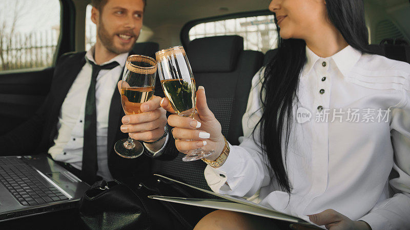 商务人士在长途商务旅行后在车里喝香槟