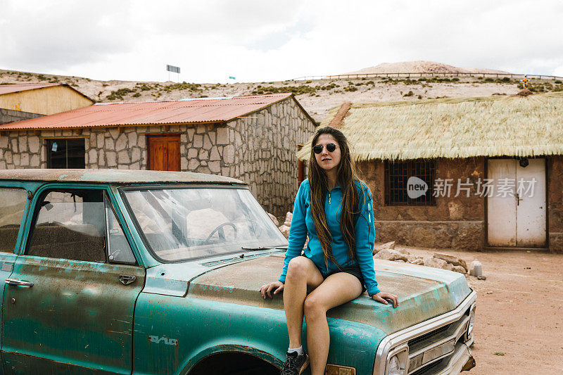 在阿塔卡马沙漠的一个小村庄里，一名妇女坐在一辆旧车上