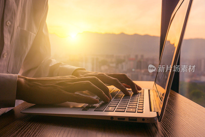一个人在日落时使用笔记本电脑