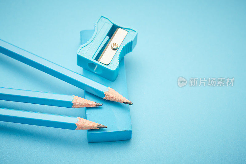 淡蓝色的铅笔、橡皮和卷笔刀