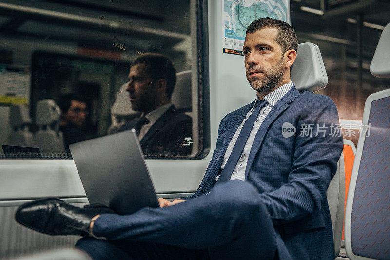 一个商人在火车上用笔记本电脑工作