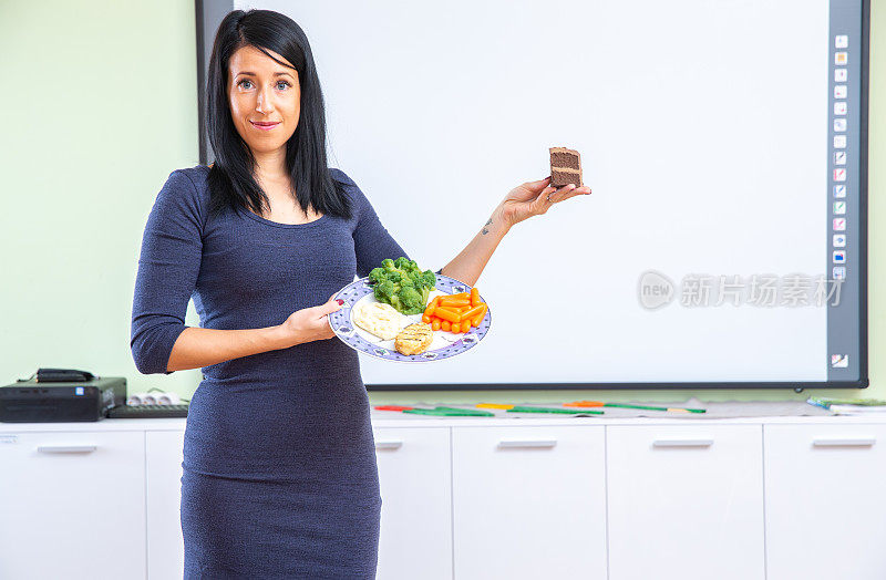 年轻女性营养学家教育关于健康饮食和生活方式-库存照片