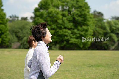 老女人在公园跑步和私人教练